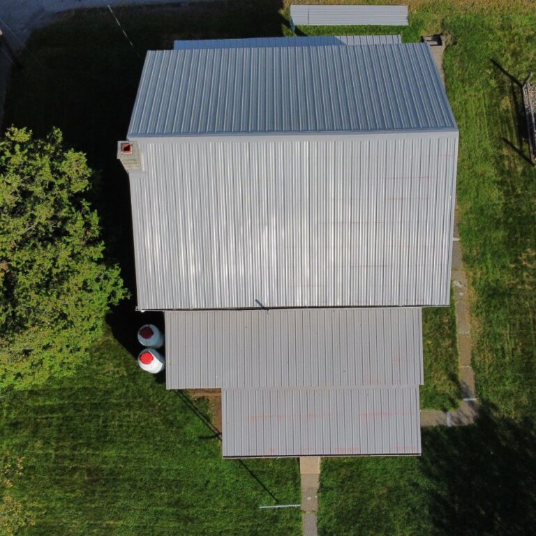 An aerial view of a completed metal roof project with multiple slanted roof tops by The Exterior Company