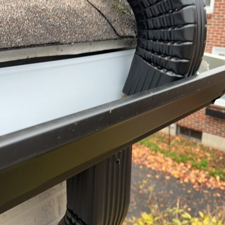 Close up view of a gutter connecting to a secondary gutter on a residential home.