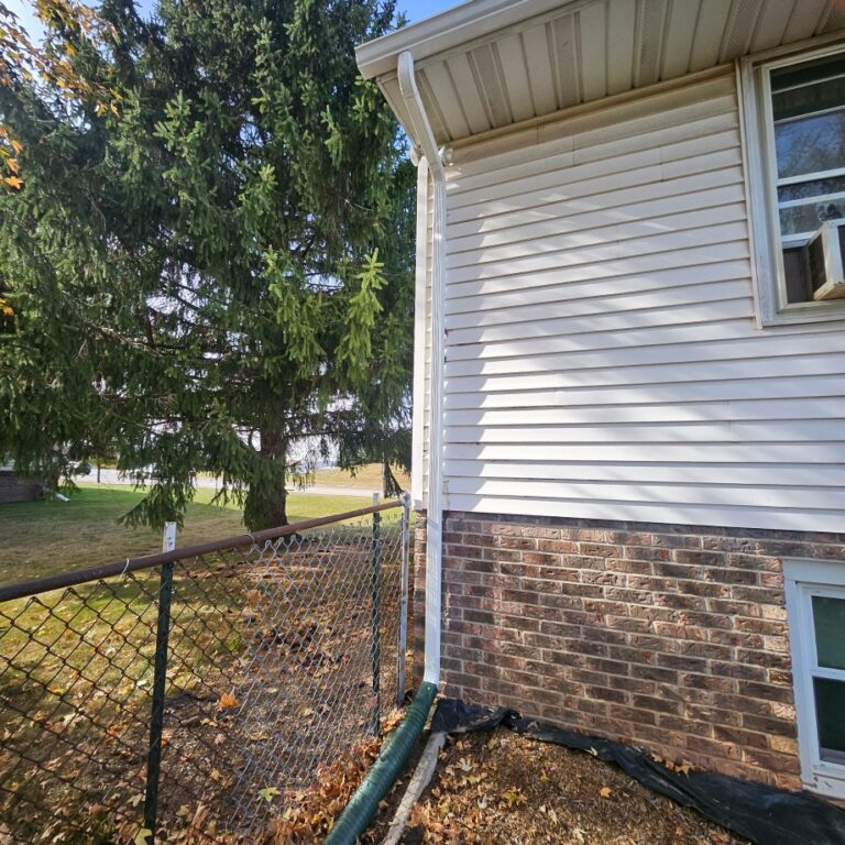 New gutters installed on a residential home with a hanging roof and siding by The Exterior Company