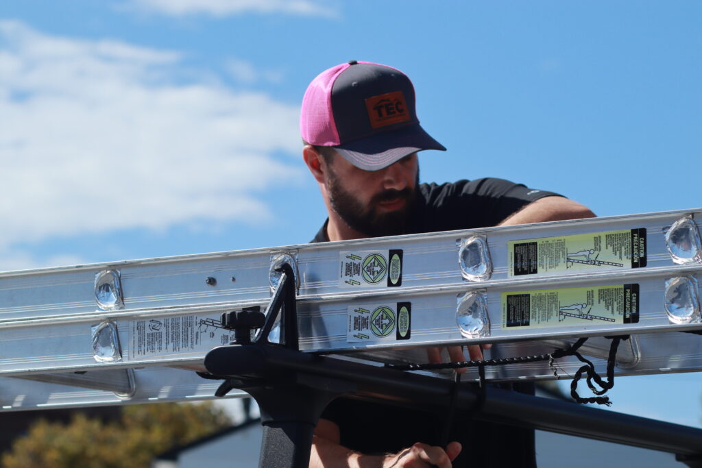 outside sales representative tying down a ladder