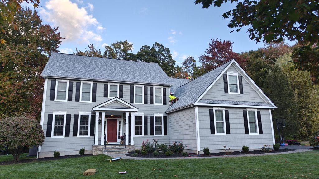 Professional roofing crew inspecting asphalt shingles on a residential home.