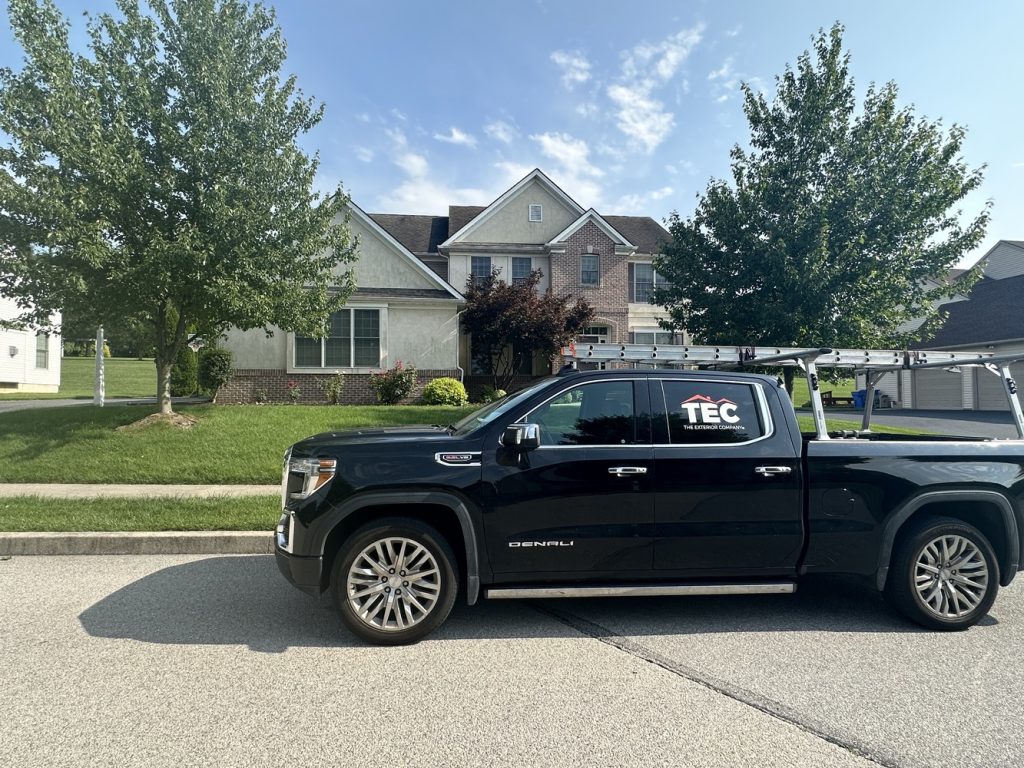 Roofing and construction company (TEC) service truck outside a residential property
