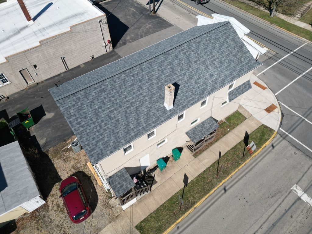 Aerial view of a residential property with a newly installed asphalt shingle roof